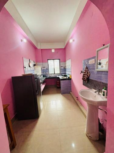 グワーハーティーにあるDreamy Den Homestayのピンクの壁と洗面台とカウンターのあるバスルーム