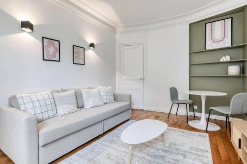 un salon avec un canapé et une table dans l'établissement Delta - Appartement parisien - 9e, à Paris