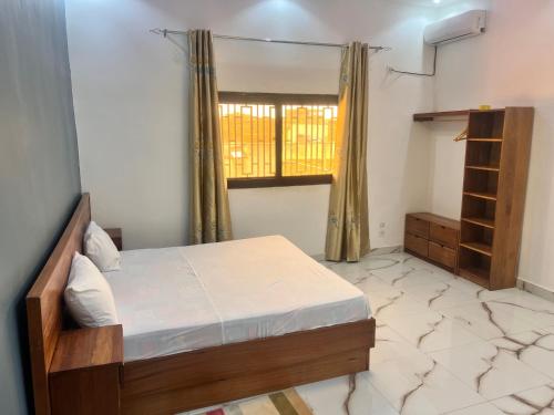 a bedroom with a bed and a window at Résidence Khadija Aéroport AIBD Confort in Rufisque
