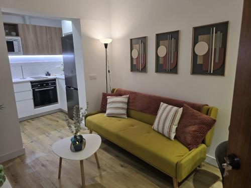 a living room with a green couch and a table at Apartamento Teror Encantado in Teror