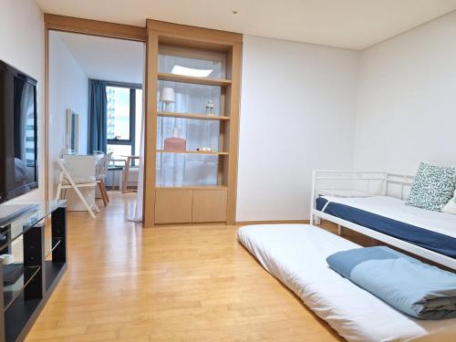 a living room with two beds and a television at Stella's Home in Seoul