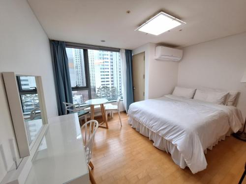 a bedroom with a white bed and a table with chairs at Stella's Home in Seoul