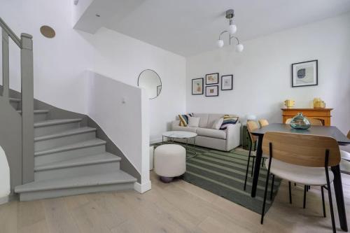 a living room with a staircase and a table at Guersant - Maison cosy 6PAX proche Etoile in Paris