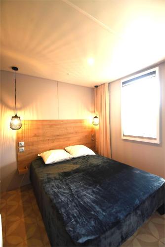 une chambre avec un grand lit et une fenêtre dans l'établissement Mobil home O'HARA 2 chambres, à Argelès-sur-Mer