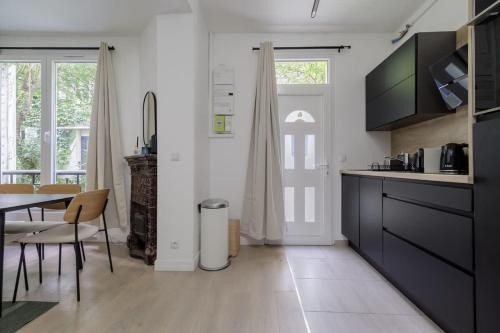 a kitchen with a table and a dining room at Guersant - Maison cosy 6PAX proche Etoile in Paris