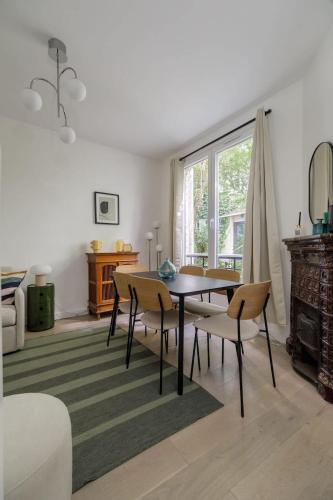 un salon avec une table et des chaises de salle à manger dans l'établissement Guersant - Maison cosy 6PAX proche Etoile, à Paris