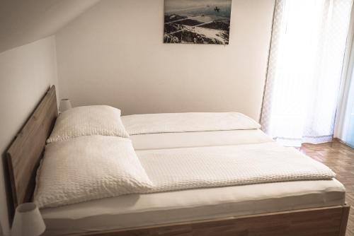 a bedroom with two beds with white sheets at Haus Dietrich am Red Bull Ring in Spielberg