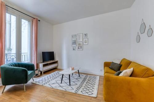 - un salon avec un canapé jaune et une télévision dans l'établissement Poissonniere -Cosy apartment near Montmartre, à Paris