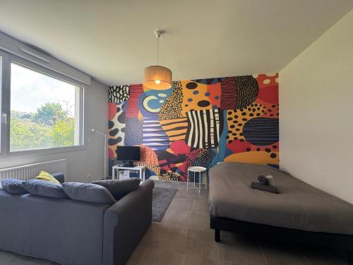 a living room with a couch and a painting on the wall at Central très proche tramway in Décines-Charpieu