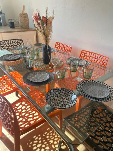 - une table en verre avec des chaises et des verres dans l'établissement Grand appartement aux portes de Strasbourg, à Ittenheim
