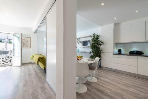 Il comprend une cuisine et un salon avec des murs blancs et du parquet. dans l'établissement Bright Apartment in the Heart of Cannes, à Cannes