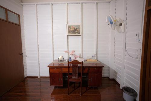 a room with a desk with a chair and a fan at บ้านแสนรัก Casa Dolce Casa, Prakhon Chai in Prakhon Chai