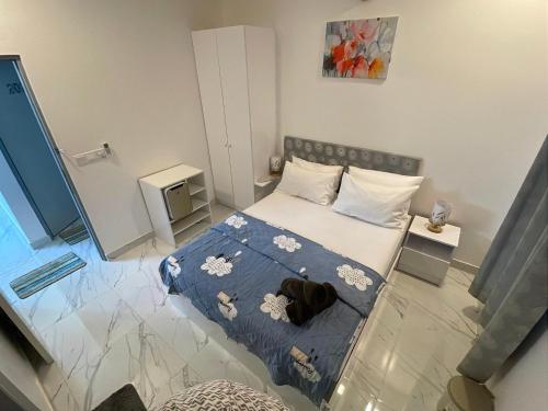 a small bedroom with a bed with a blue blanket at Empyrean Stay, Maldives in Thulusdhoo