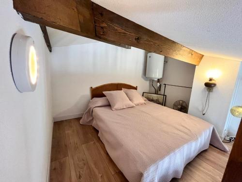 - une chambre avec un lit et du parquet dans l'établissement Joli Mazet, T2-3 proche centre ville, à Sainte-Maxime