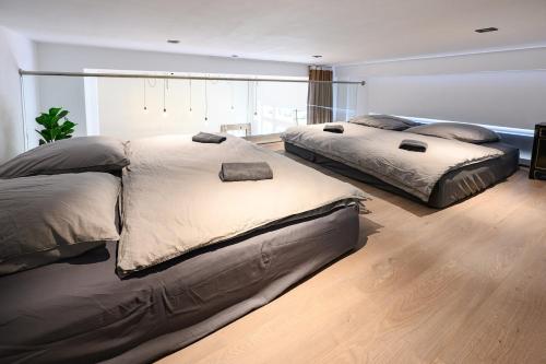 two beds in a large bedroom with wood floors at Cozy Lofts Next To Berliner Wall in Berlin