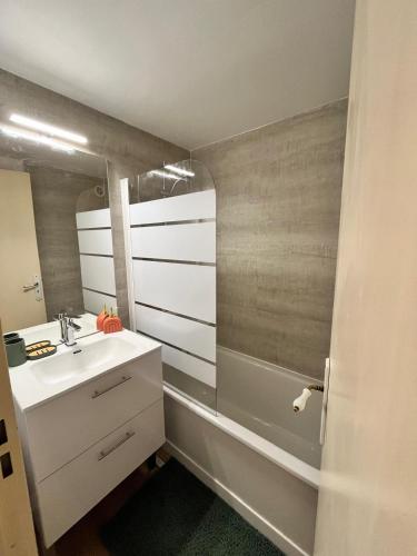 une salle de bain avec un lavabo et une baignoire dans l'établissement Joli Mazet, T2-3 proche centre ville, à Sainte-Maxime