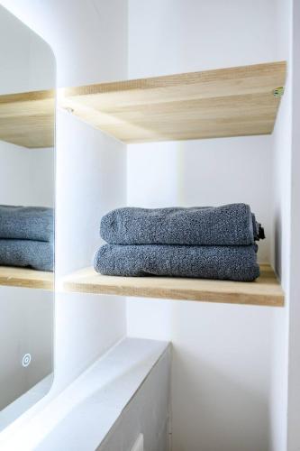 a closet with wooden shelves and blue towels at Cozy Lofts Next To Berliner Wall in Berlin