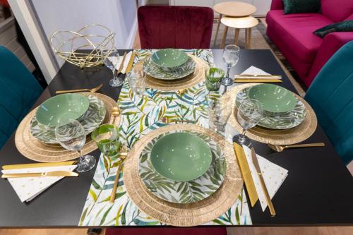 a table with green plates on top of it at Casa Inca Calais - Peruanita - Parking Public Free in Calais