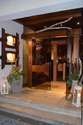 a store front with a large glass window with potted plants at Hotel Spessartstuben in Haibach