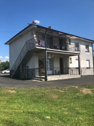 - un grand bâtiment blanc avec un balcon dans l'établissement Location saisonnière, à Saint-Gérons