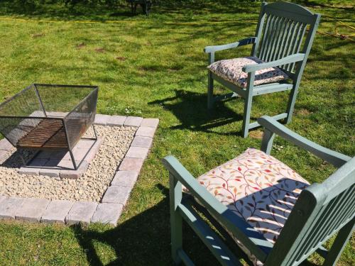 two chairs and a fire place in a yard at The Potting Shed in Manuden
