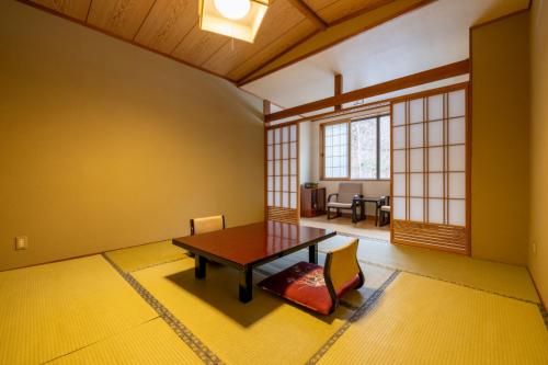a dining room with a wooden table and chairs at Fujisan Ryokan in Hanamaki