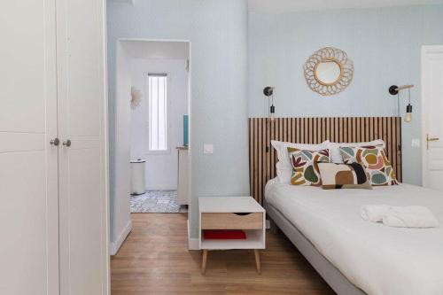 une chambre avec deux lits et un miroir au mur dans l'établissement Greneta - Spacious Flat Montorgueuil 4PAX, à Paris