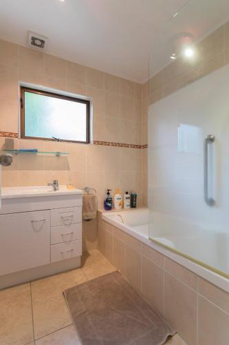 a bathroom with a tub and a sink and a shower at Joe & Mary's Cosy homestay room in Auckland