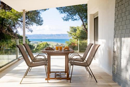 a table and chairs on a patio with a view of the ocean at Jasmin House - Sea view - In town in Skála Oropoú