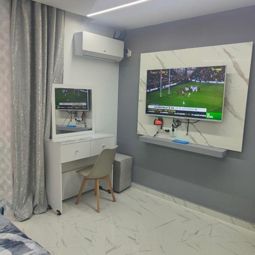 a bedroom with a tv and a chair in a room at APPARTEMENT f1 ANNABA CENTRE VILLE in Annaba