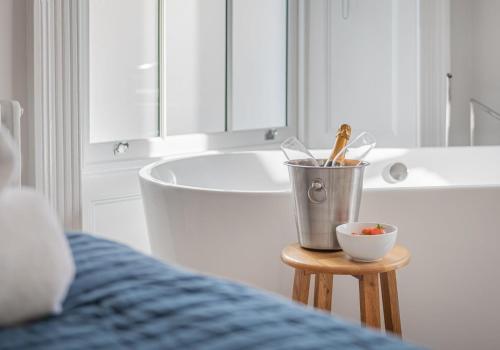 a bathroom with a tub and a bucket in front of a sink at Luxury Apartment in Bowness in Bowness-on-Windermere