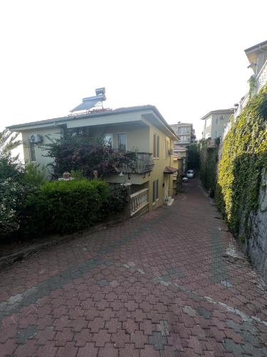 a house on a brick road next to a building at Villa with pool in Goldcity tourism complex in Kargicak