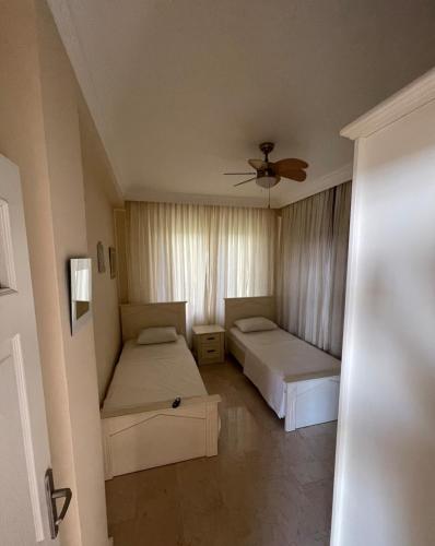 a bedroom with two beds and a ceiling fan at Villa with pool in Goldcity tourism complex in Kargicak