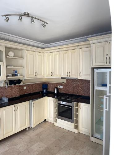 a white kitchen with white cabinets and appliances at Villa with pool in Goldcity tourism complex in Kargicak