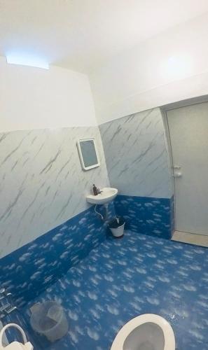 a bathroom with a sink and a toilet at Point Break Varkala in Varkala