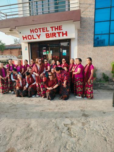 a group of people posing for a picture in front of a building at Hotel The Holy Birth in Lumbini