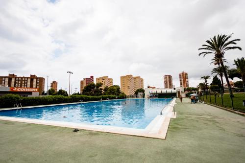 a large swimming pool with a city in the background at Cozy Apartment with Sea and Mountain Views in Benidorm in Benidorm