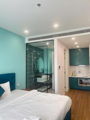 a bedroom with a large white bed and a bathroom at Hillside apartment sunset town city in Phu Quoc