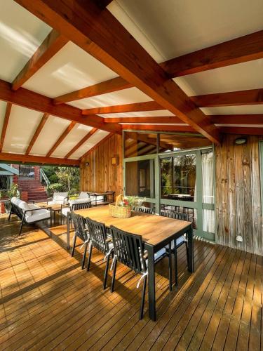 a wooden deck with a table and chairs on it at Bush Retreat on the Bay in McCrae