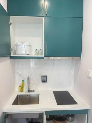 a kitchen counter with a sink and blue cabinets at Hillside apartment sunset town city in Phu Quoc
