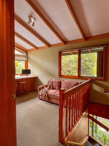 a living room with a couch and two windows at Bush Retreat on the Bay in McCrae
