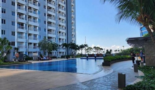a swimming pool in front of a large building at Apartment Orchard Tanglin Pakuwon Mall in Surabaya