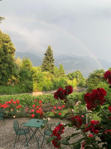 a table and chairs in a garden with flowers at Hotel Loveno in Menaggio