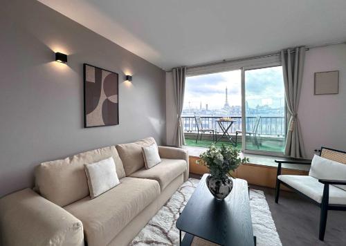 un salon avec un canapé et une grande fenêtre dans l'établissement Champs - Elysees view studio with balcony - AC for 3, à Paris