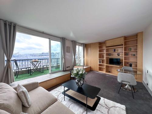 un salon avec un canapé et une grande fenêtre dans l'établissement Champs - Elysees view studio with balcony - AC for 3, à Paris
