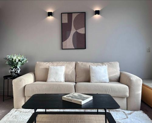 un salon avec un canapé et une table basse dans l'établissement Champs - Elysees view studio with balcony - AC for 3, à Paris