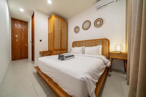 a bedroom with a large white bed and a table at Exquisite New Villa with Unmatched Amazing Views, Huge Pool - 4 Elegant Bedrooms! in Canggu