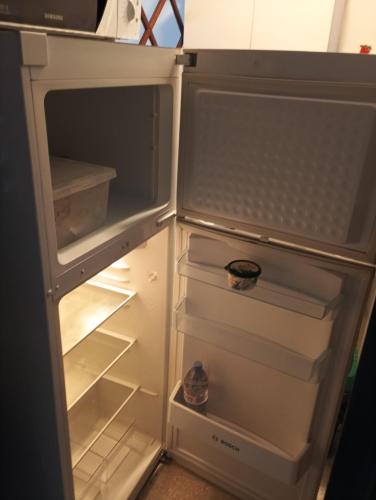 - un réfrigérateur ouvert avec porte ouverte et haut de gamme dans l'établissement Appartement T2 près de la mer, à Canet