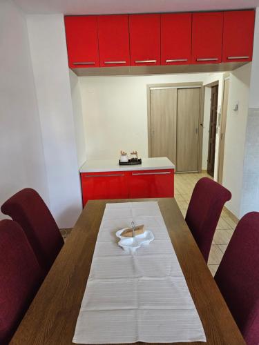 a dining room with a table and red cabinets at K&N centar Doboj in Doboj
