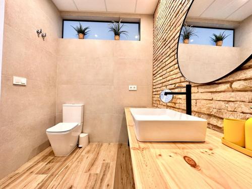 een badkamer met een wastafel, een toilet en een spiegel bij Mediterranean Apartament in Valencia